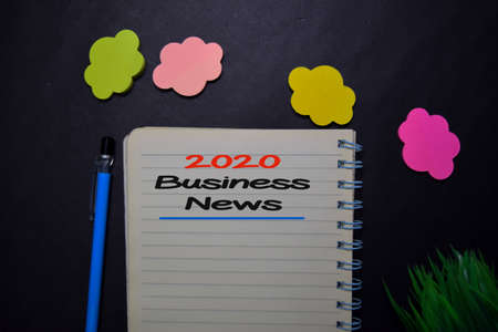 2020 Business News write on a book isolated on black table.の写真素材