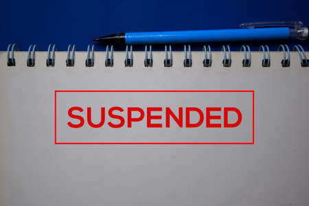 Suspended write on a book isolated on blue background.の写真素材