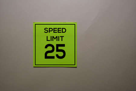 Speed Limit 25 write on a sticky note isolated on office desk.