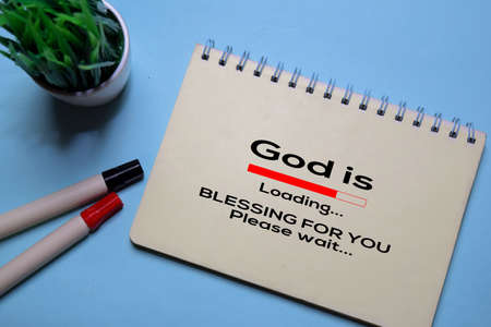 God Is Loading and Blessing For You write on a book isolated on office desk. Christian faith concept