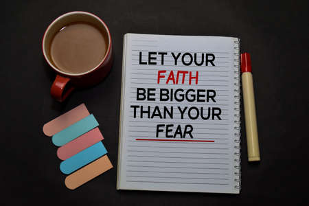 Let Your Faith Be Bigger Than Your Fear write on a book isolated on office desk. Christian faith...