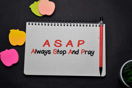 ASAP - Always Stop And Pray write on a book isolated on office desk. Christian faith conceptの写真素材