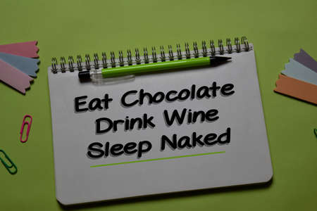 Eat Chocolate. Drink Wine. Sleep Naked write on a book isolated on office desk.