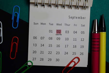 Top view September monthly Calendar and marked 2nd labor day isolated on office desk