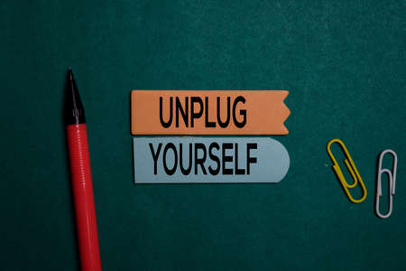 Unplug Yourself write on a sticky note isolated on Office Deskの写真素材