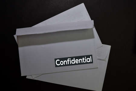 Confidential write on a white envelope isolated on office desk.の写真素材