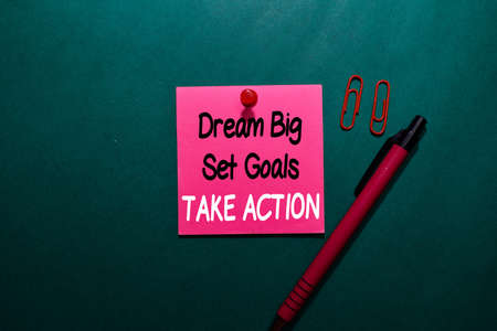 Dream Big Set Goals Take Action write on a sticky note isolated on Office Deskの写真素材