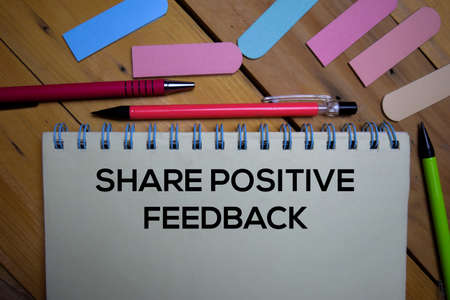 Share Positive Feedback write on a book isolated on wooden background.の写真素材