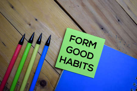 Form Good Habits write on a sticky note isolated on wooden background.の写真素材