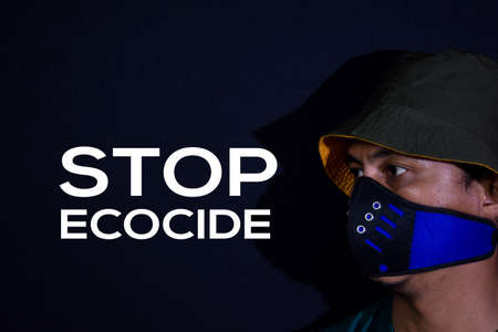 Bekasi. Indonesia. March 7 2020 : Young man use masker and stop ecocide write on dark black...