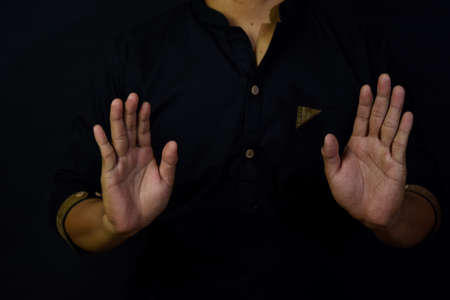 Asian man muslim takbir and solat take his hands up. Islamic praying concept on black background....