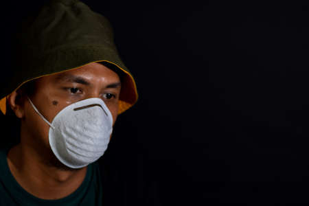 Bekasi. Indonesia. March 7 2020 : A young man in a mask on a black background. Title about the outbreak of the corona virusのeditorial素材