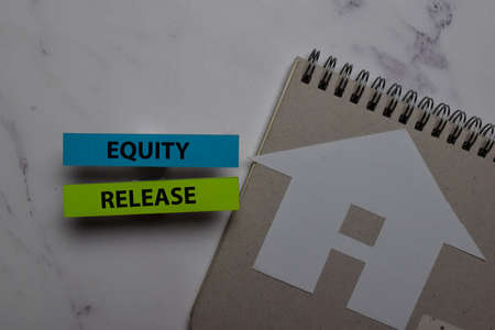 Equity Release write on sticky note and house made from paper isolated on Office Desk. Retirement conceptの写真素材
