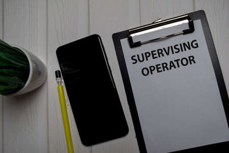 Supervising Operator write on a paperwork isolated on wooden table.の写真素材