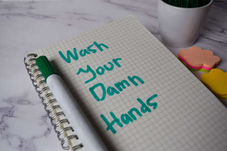 Wash Your Damn Hands write on a book and keyword isolated on Office Desk. Healthcare/Medical Concept