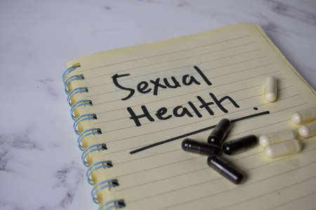 Sexual Health write on a book and keyword isolated on Office Desk. Healthcare/Medical Conceptの写真素材