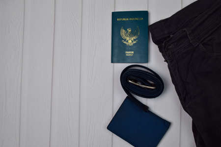 Passport, Wallet, buckle and gray Jeans on wooden table. Traveling conceptの写真素材