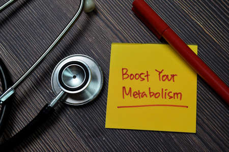 Boots Your Metabolism write on sticky note isolated on wooden table.の写真素材