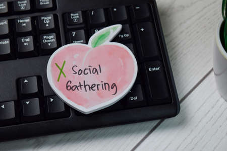 Social Gathering write on sticky note isolated on wooden table.