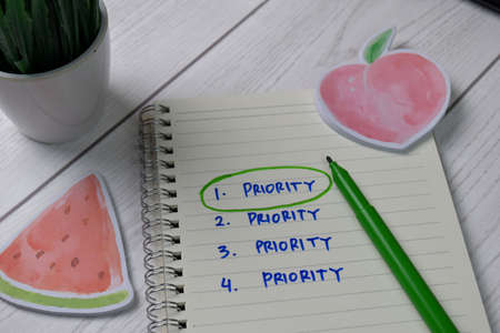 Priority write on a book. Supported by an additional services isolated wooden table.の写真素材