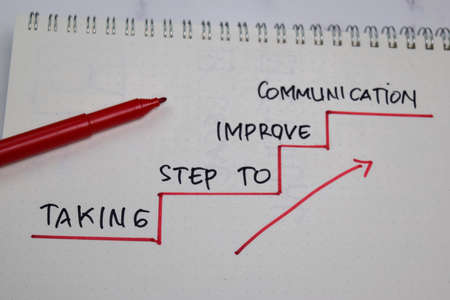 Taking Step to Improve Communication write on a book isolated on wooden table.の写真素材