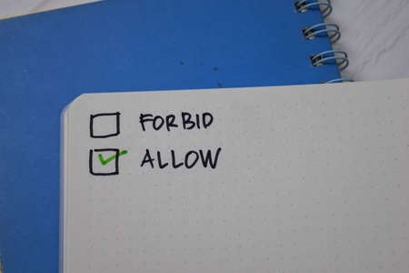 Forbid and Allow write on a book. Supported by an additional services isolated wooden table.の写真素材