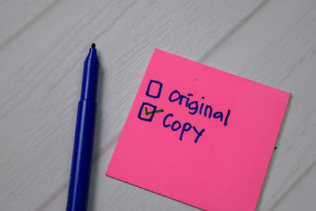 Copy and Original write on a sticky note. Supported by an additional services isolated wooden table.の写真素材