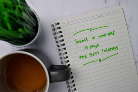 Invest In Yourself It Pays The Best Interest write on a book isolated wooden table.