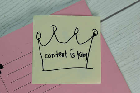 Content is King write on sticky note isolated on Wooden Table.の写真素材