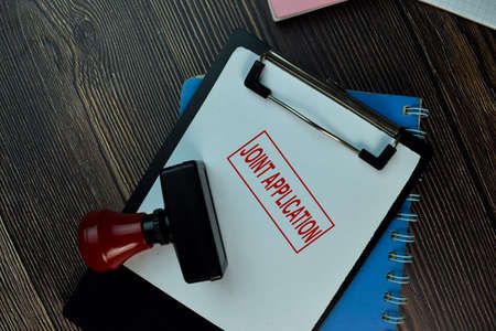 Red Handle Rubber Stamper and Joint Application text isolated on the table.の写真素材