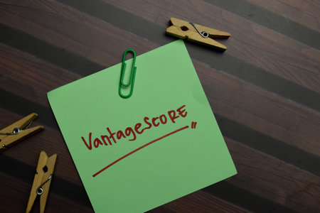 Vantagescore write on sticky notes isolated on Wooden Table.