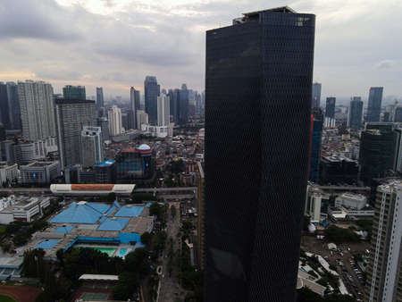 Aerial view of highway intersection and buildings in the city of Jakarta and noise cloud with...