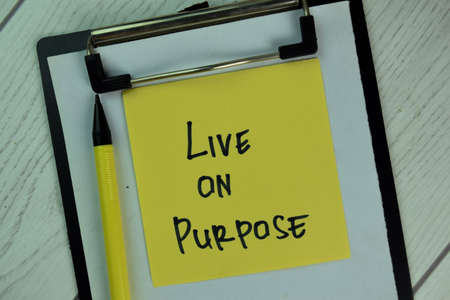 Live on Purpose write on sticky notes isolated on Wooden Table.の写真素材