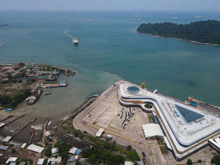 Aerial view of pelabuhan merak is a marine port and town harbor island of merak in the sunlight morning. Ferry boats, with noise cloud and cityscape. Banten, Indonesia, March 3, 2021のeditorial素材