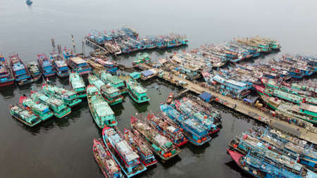 Aerial drone view of Muara Angke Beach with wooden boats leaning beside the pier. With noise cloud after rain. Jakarta, Indonesia. March 21, 2021のeditorial素材