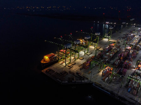 Aerial view of Container ship loading and unloading in deep sea port, logistic import and export freight transportation by container ship in open sea at night. Jakarta, Indonesia, April 12, 2021のeditorial素材
