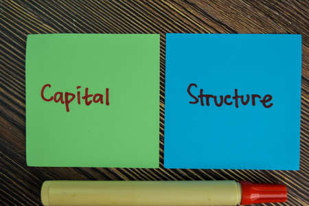 Capital Structure write on sticky notes isolated on Wooden Table.の写真素材