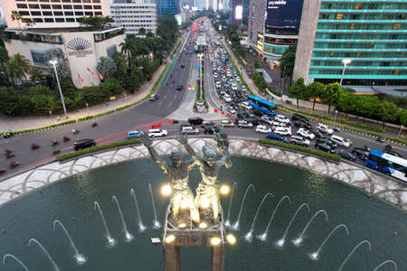 Aerial view of the city traffics at the Hotel Indonesia Roundabout. Vehicles are moving on the road between buildings. Jakarta, Indonesia, April 28, 2021のeditorial素材