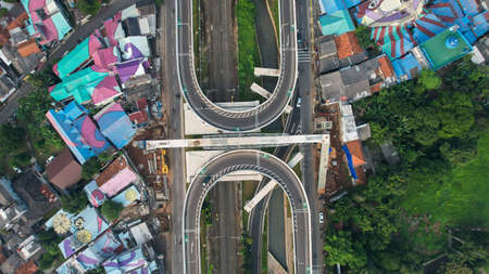Aerial view of infinity sign traffic junction cross road with car transport. Jakarta, May 25, 2021