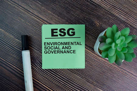 ESG - Environmental Social and Governance write on sticky notes isolated on Wooden Table.の写真素材
