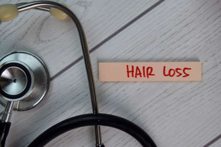 Hair Loss write on sticky notes isolated on Wooden Table.