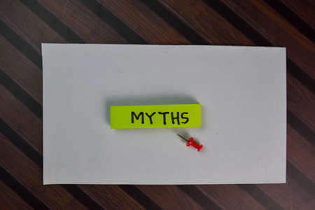 Myths write on sticky notes isolated on Wooden Table.の写真素材