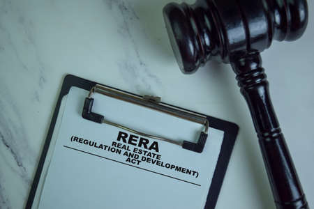 RERA - Real Estate. Regulation and Development Act write on a paperwork isolated on Wooden Table.