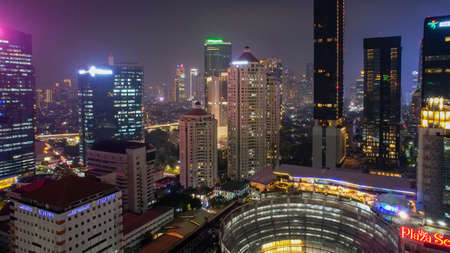 Aerial view on highways and skyscrapers. Spectacular nighttime skyline of a big modern city at...