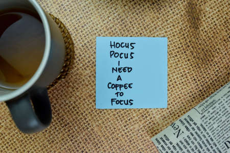 Hocus Pocus I Need A Coffee To Focus write on sticky notes isolated on Wooden Table.の写真素材