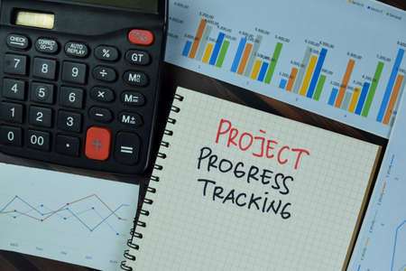Project Progress Tracking write on a book isolated on Wooden Table.