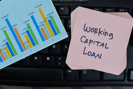 Concept of Working Capital Loan write on sticky notes isolated on Wooden Table.の写真素材