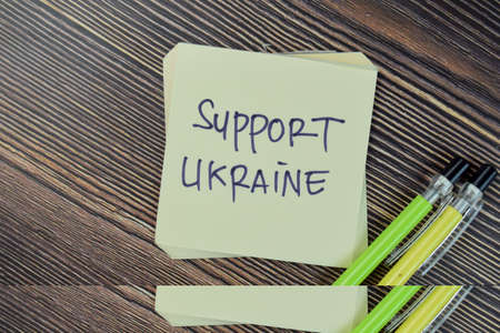 Concept of funny smiley face write on sticky notes isolated on Wooden Table.の写真素材