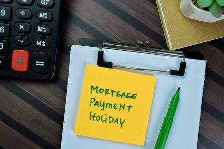 Concept of Mortgage Payment Holiday write on sticky notes isolated on Wooden Table.の写真素材