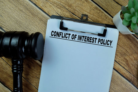 Concept of Conflict of Interest Policy write on paperwork isolated on Wooden Table.の写真素材